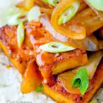 Close up Korean gochujang tofu stew with kimchi served with white rice featuring a title overlay.