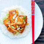 Overhead Korean gochujang tofu stew with kimchi served with white rice.