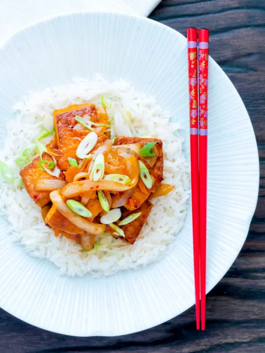 Overhead Korean gochujang tofu stew with kimchi served with white rice.