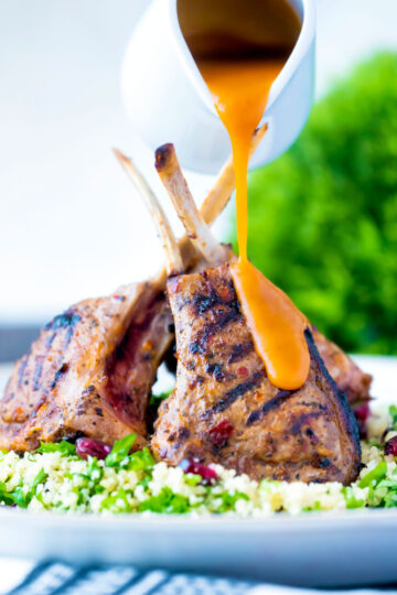 Harissa lamb chops served on herby buttered couscous with a spicy sauce.