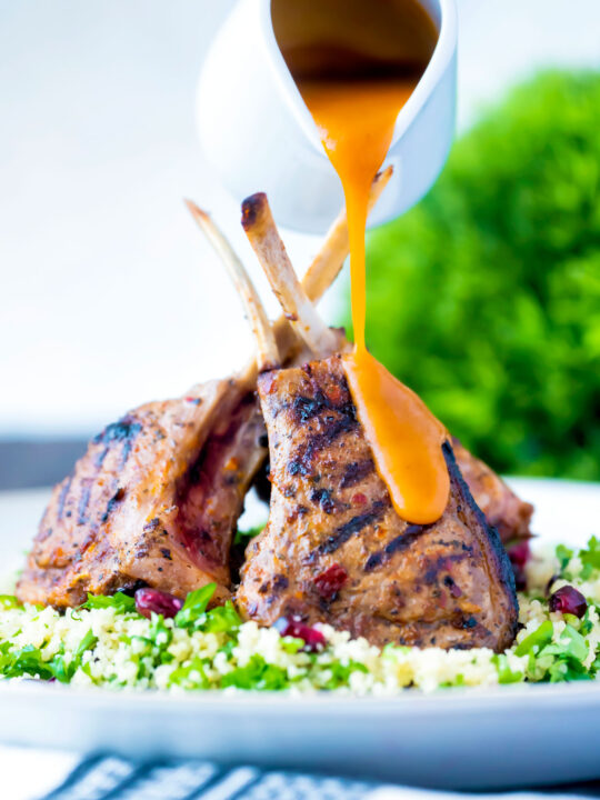 Harissa lamb cutlets served on herby buttered couscous with a spicy sauce.
