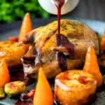 Red wine and red currant sauce poured over whole roast partridge.