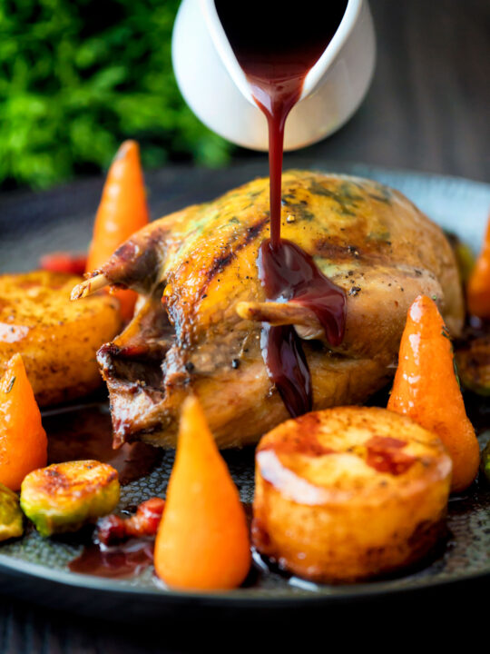 Red wine and red currant sauce poured over whole roast partridge.