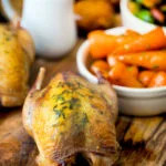 Whole roast partridges served with vegetables.
