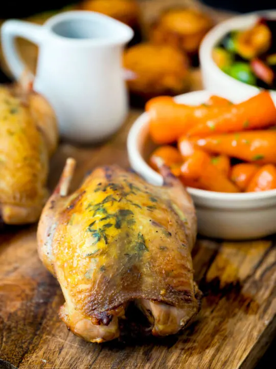 Whole roast partridges served with vegetables.