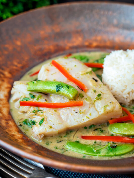 Close up Thai green fish curry made with cod and sugar snap peas.