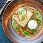 Overhead Thai green fish curry made with cod and sugar snap peas.