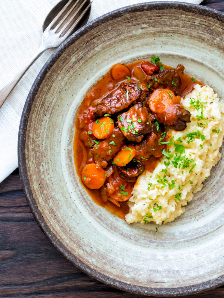 Overhead Moshari kokkinisto a Greek beef and tomato stew served with celeriac mash.