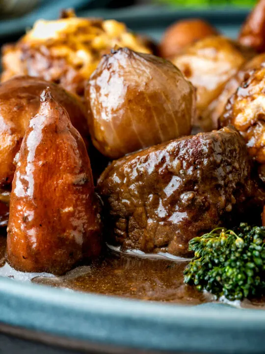 Close up British beef and ale stew with dumplings, carrots and potatoes.