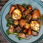 Overhead British beef and ale stew with dumplings, carrots and potatoes featuring a title overlay.