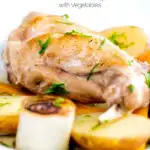 Close up braised rabbit legs served with leek rings and potatoes featuring a title overlay.