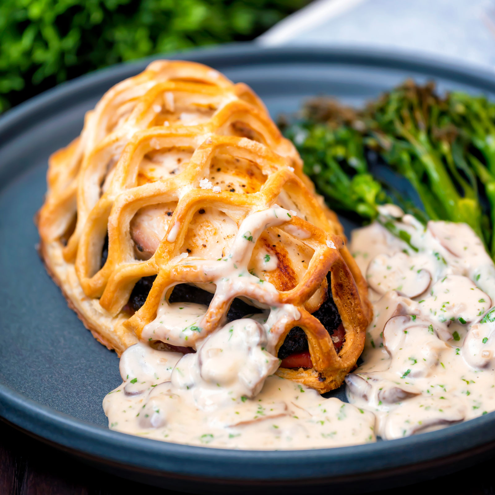 Chicken en croute served with a mushroom cream sauce and roasted tenderstem broccoli.