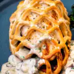 Close up Chicken en croute with a mushroom cream sauce featuring a title overlay.