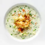 Overhead chunky creamy cauliflower soup with a paprika garnish.