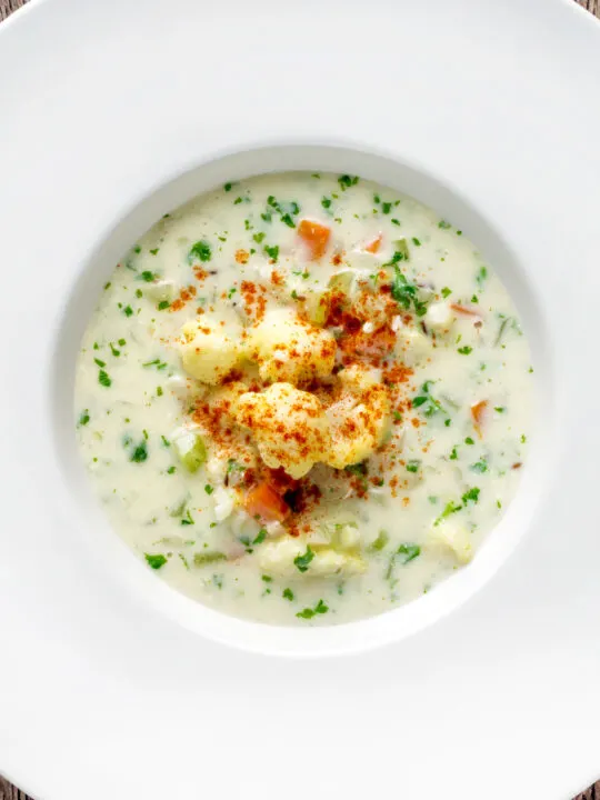 Overhead chunky creamy cauliflower soup with a paprika garnish.