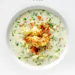 Overhead chunky creamy cauliflower soup with a paprika garnish featuring a title overlay.