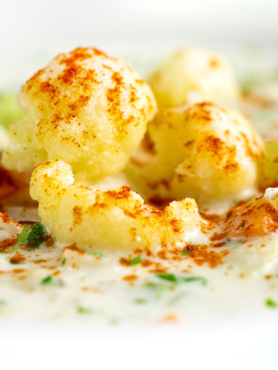 Close up chunky creamy cauliflower soup with a paprika garnish.