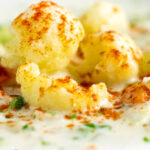 Close up chunky creamy cauliflower soup with a paprika garnish featuring a title overlay.