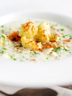 Chunky creamy cauliflower soup with a paprika garnish.