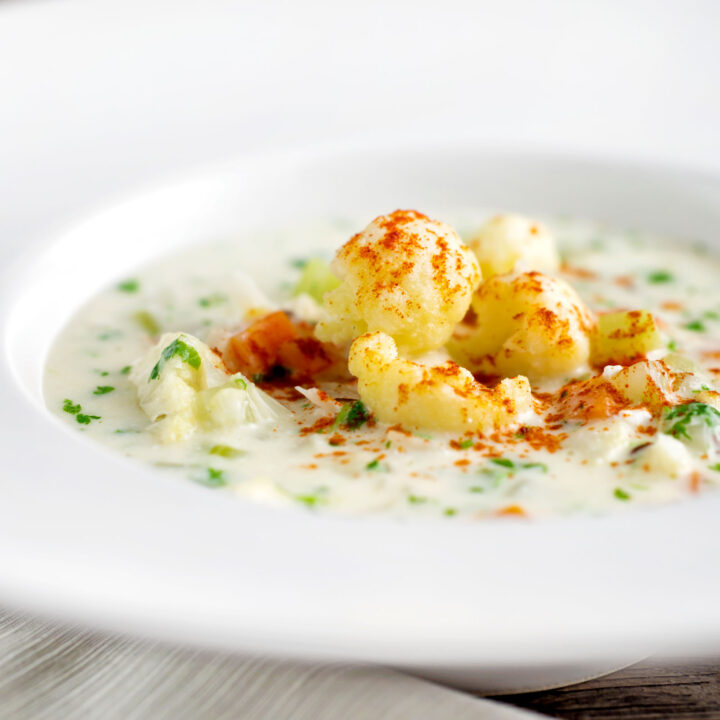 Chunky creamy cauliflower soup with a paprika and parsley garnish.