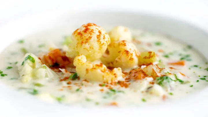 Chunky creamy cauliflower soup with a paprika and parsley garnish.