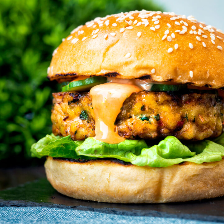 Spicy cod fish burger with sriracha mayonnaise, lettuce and cucumber.