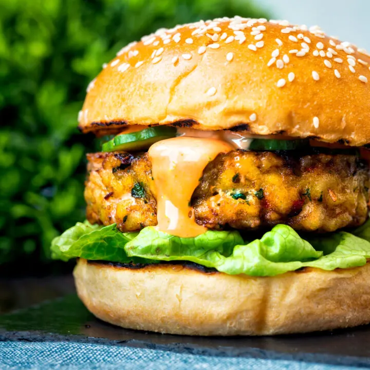 Spicy cod fish burger with sriracha mayonnaise, lettuce and cucumber.