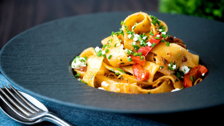Harissa pappardelle pasta with with roasted peppers, feta cheese and snipped chives.