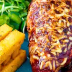 Close up British pub favourite hunters chicken with BBQ sauce, cheddar cheese and bacon.