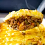 Steaming hot portion of lamb shepherds pie on a spoon.