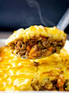 Steaming hot portion of lamb shepherds pie on a spoon.