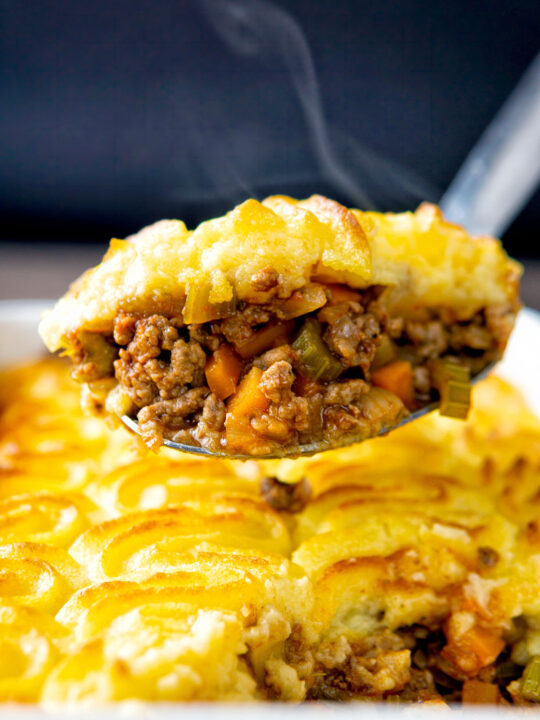 Steaming hot portion of lamb shepherds pie on a spoon.