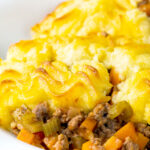 Minced lamb shepherds pie served in a white bowl.