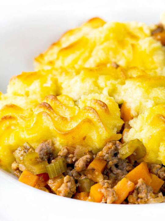 Minced lamb shepherds pie served in a white bowl.