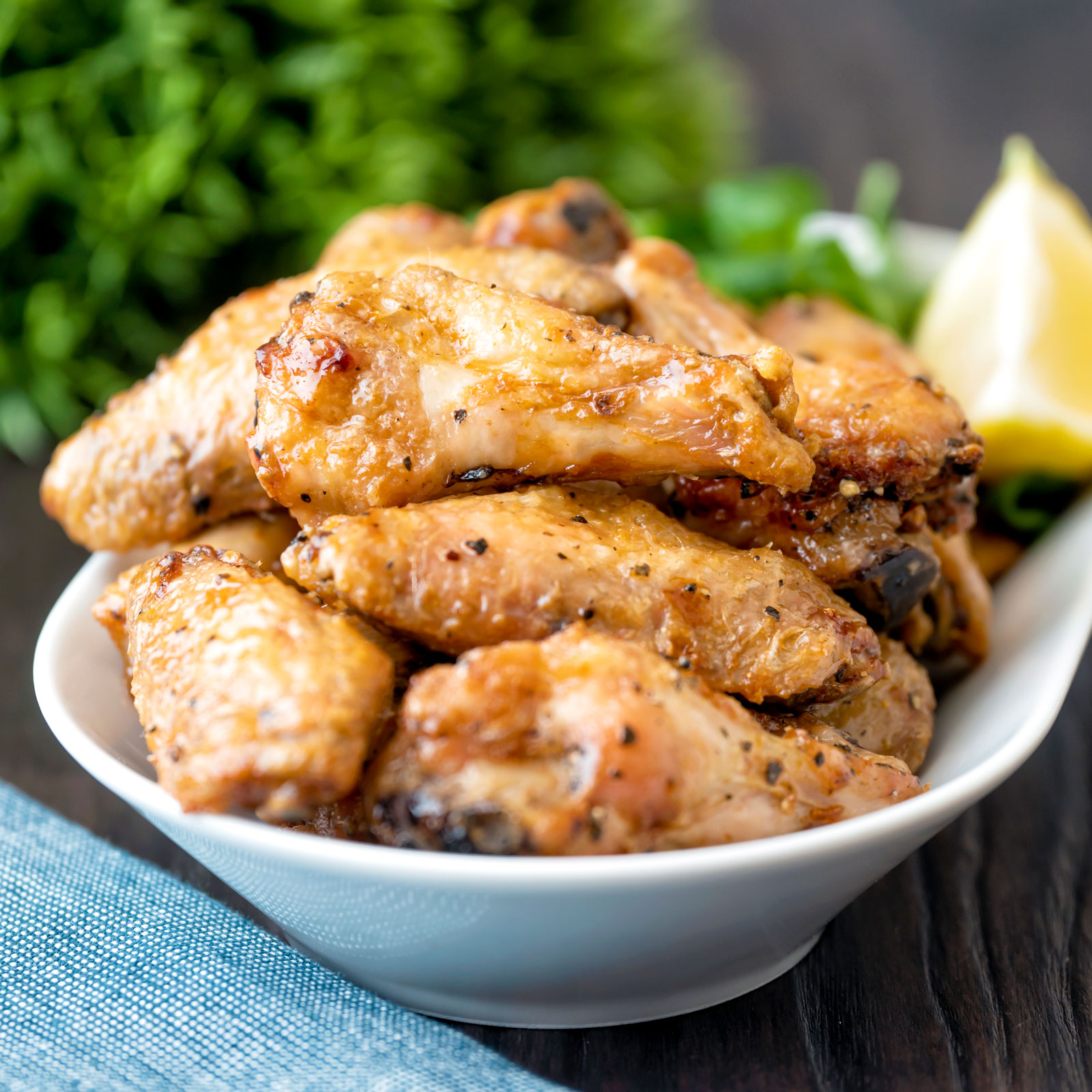 Crispy lemon pepper wings served with a green salad and lemon wedge.