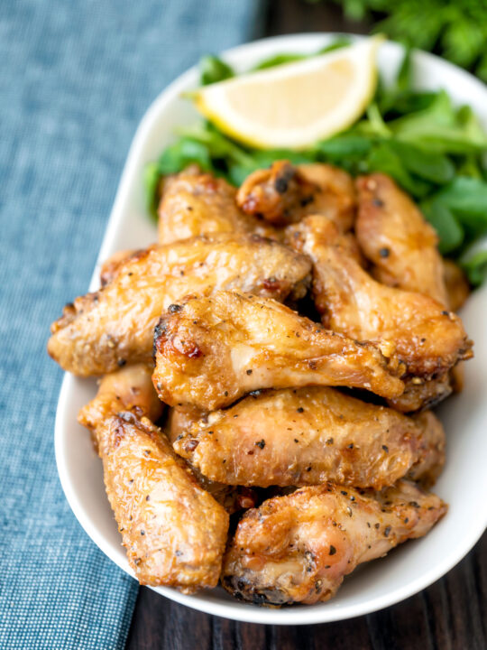 Crispy lemon pepper chicken wings served with a green salad.