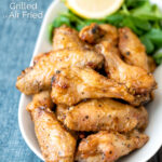 Crispy lemon pepper chicken wings served with a green salad featuring a title overlay.