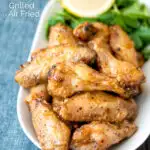 Crispy lemon pepper chicken wings served with a green salad featuring a title overlay.