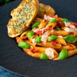 Italian penne arrabbiata served with basil, parmesan, black pepper and cheesy garlic bread.