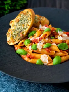 Italian penne arrabbiata served with basil, parmesan, black pepper and cheesy garlic bread.