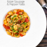 Overhead sausage and pepper orecchiette pasta in a light tomato sauce with fresh parsley featuring a title overlay.