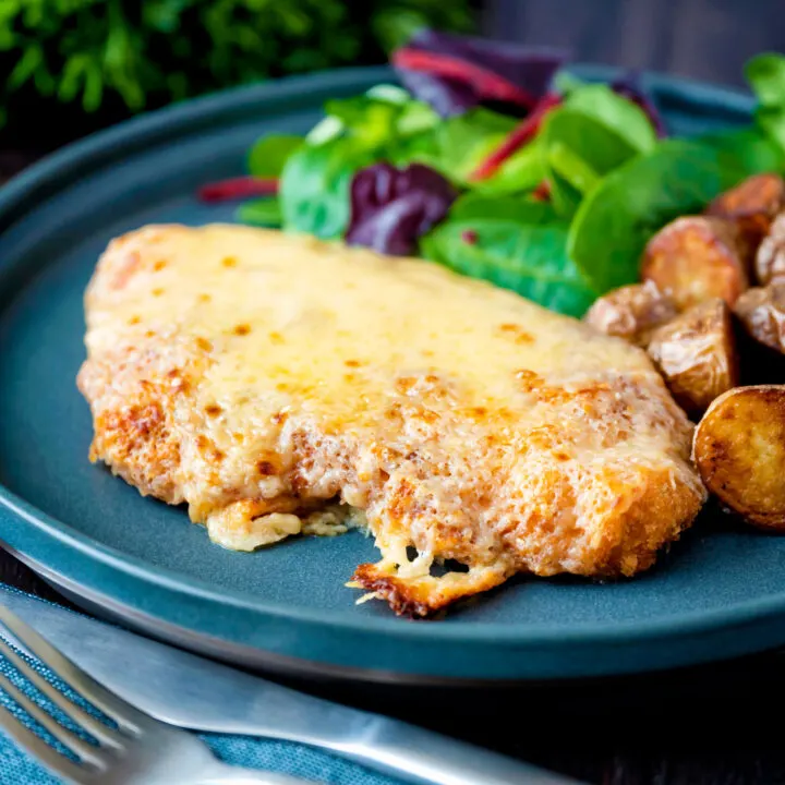 Chicken parmo, cheese topped fried breaded chicken served with fried potatoes.