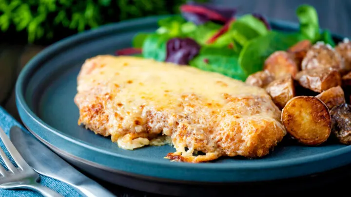 Chicken parmo, cheese topped fried breaded chicken served with fried potatoes.