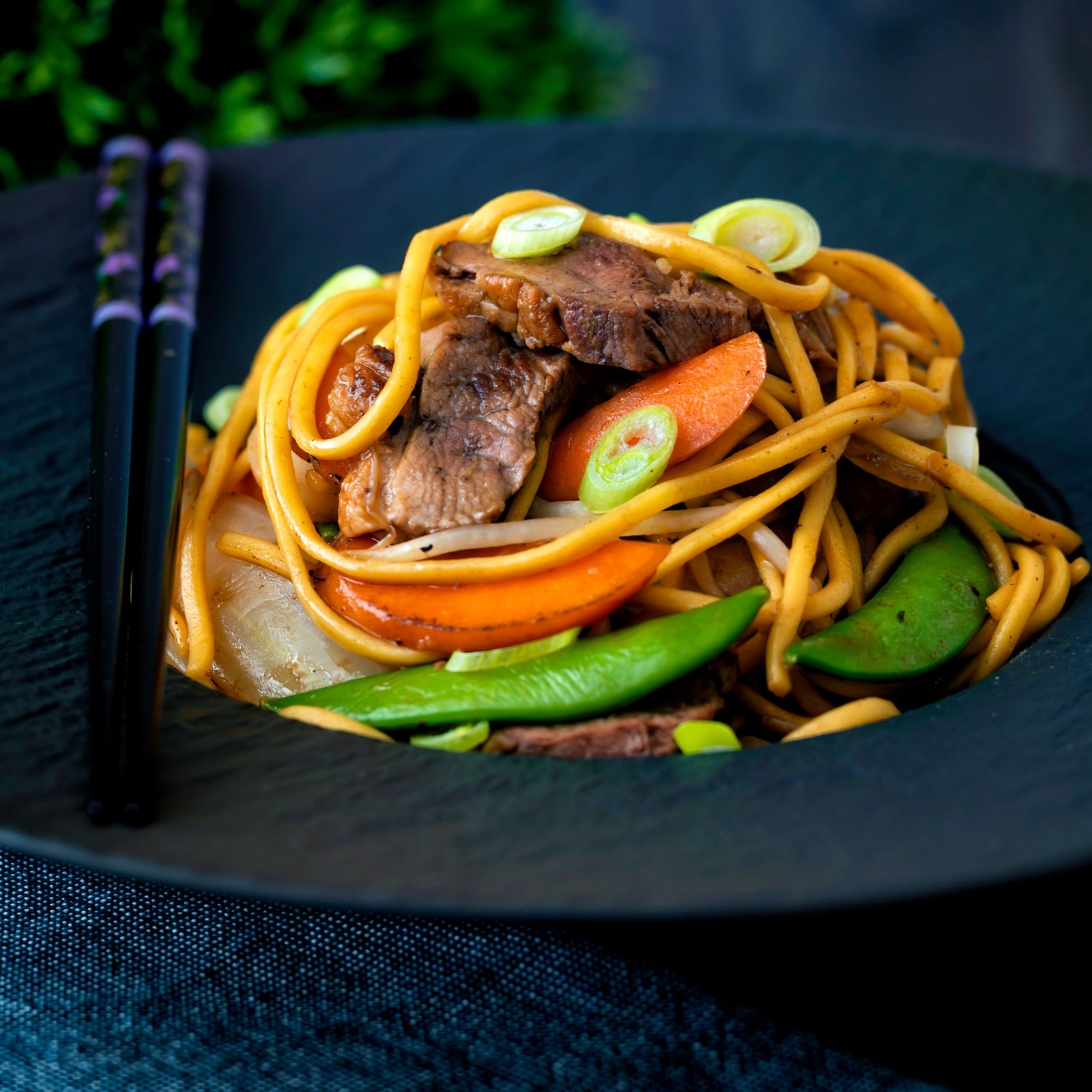 Chinese hoisin duck chow mein stir fry with noodles, carrots and sugar snap peas.