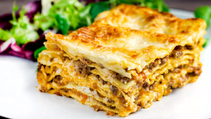 Perfectly layered lasagna bolognese with a crispy cheesy topping served with a side salad.