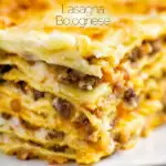 Close up Lasagna bolognese, baked to perfection served with a side salad featuring a title overlay.