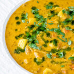 Close up chicken mulligatawny soup with coconut milk featuring a title overlay.