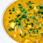 Close up chicken mulligatawny soup with coconut milk featuring a title overlay.