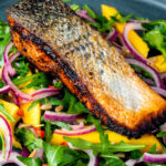 Pan fried jerk salmon fillet served with mango and rockets salad.