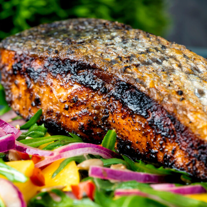 Pan fried crispy skinned jerk salmon fillet served with mango and rocket salad.